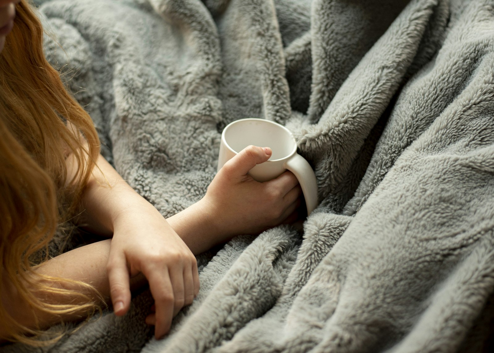woman holding white ceramic mug