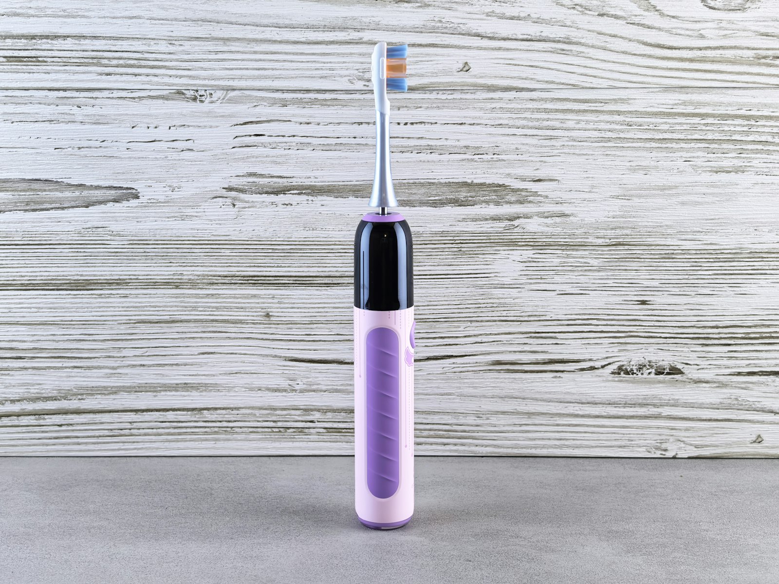 A purple electric toothbrush on a gray surface