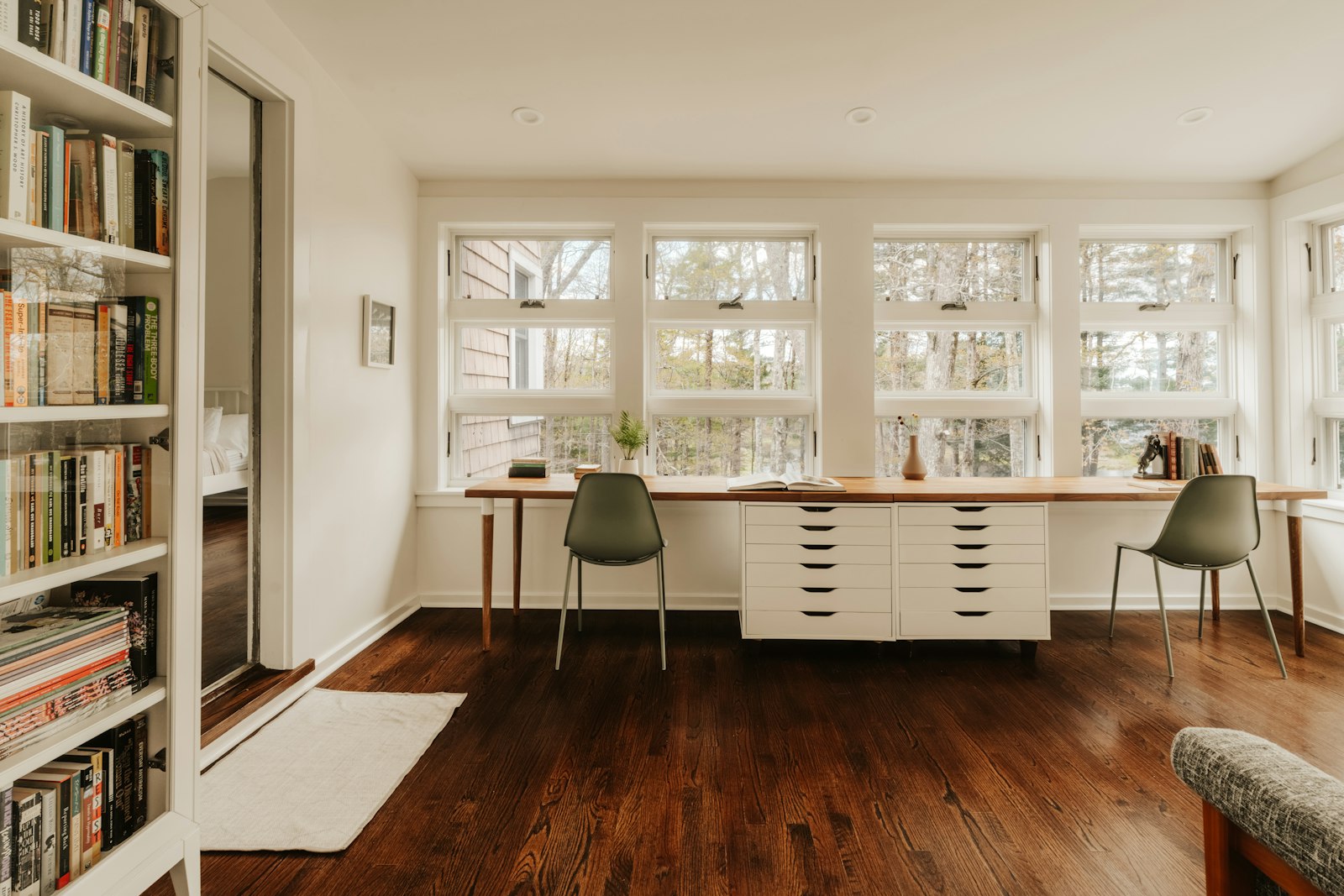 Bright room with bookshelves and two desks by windows